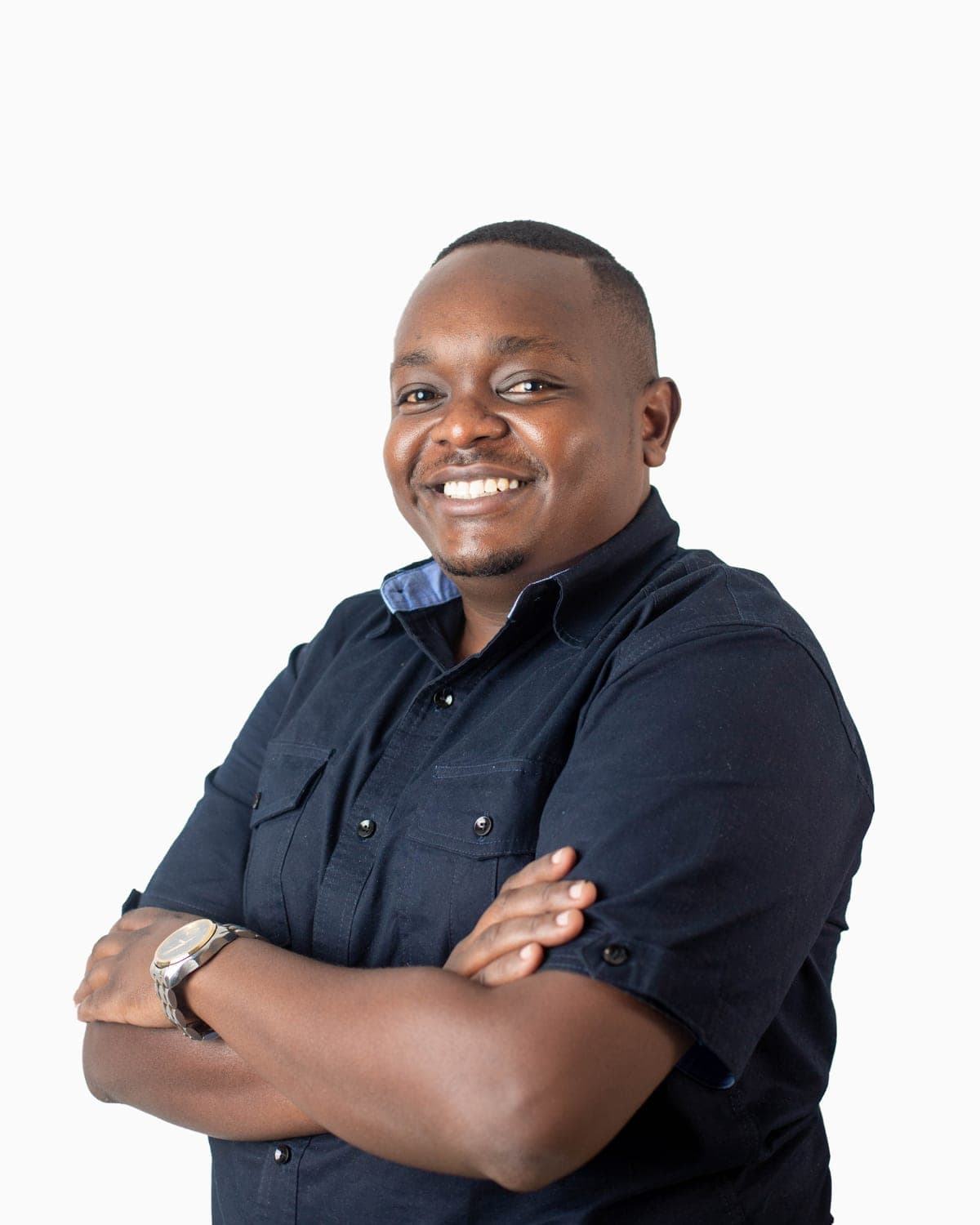 Kevin Mwau, Director of Altic Consult, smiling with arms folded against a white studio backdrop.